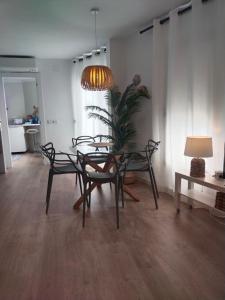 ein Esszimmer mit einem Tisch, Stühlen und einer Lampe in der Unterkunft Apartament Les Cases in Les Cases d'Alcanar