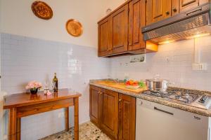 een keuken met houten kasten, een wastafel en een fornuis bij Casa Milly - Happy Rentals in Desenzano del Garda