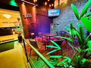 瓜鲁柳斯ON HOSTEL II Gru Aeroporto Translado 24 hs的一间设有桌椅和植物的餐厅