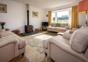 a living room with couches and a fire place at 15 Lon Cernyw in Abersoch