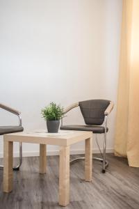 a chair and a table with a potted plant on it at Toschis Station-Motel-Wirtshaus-an der Autobahn-Bowling in Zella-Mehlis