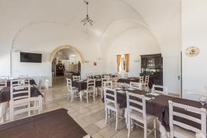 a dining room with tables and white chairs at Agriturismo Donna Teresa in Mottola