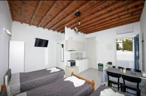una camera con due letti e un tavolo e una cucina di Karboni Hotel a Mykonos Città