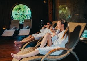 a man and a woman sitting in a wicker chair at Hotel Tri Studničky - Adult friendly in Belá