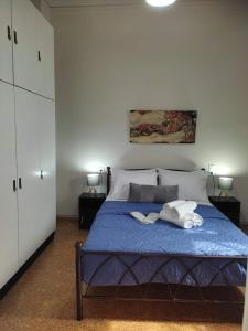 a bedroom with a blue bed with two towels on it at D&G City Centre Home in Heraklio