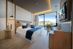 um quarto com uma cama grande e uma janela grande em H10 Costa Mogán em Playa del Cura
