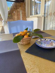 ein Obstkorb auf einem Tisch mit einem Teller in der Unterkunft Le tre stelle in Castellabate