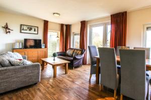 un soggiorno con un divano e un tavolo di KG - Vakantiewoning 11 a Opperdoes