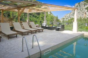 a patio with chairs and a swimming pool at Rustic luxury Villa Fulmin in Malo Grablje