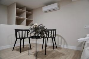 two chairs and a table with flowers on it at Estudio Veintisiete in Morón de la Frontera