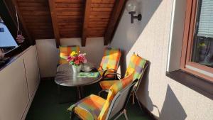 Una mesa y sillas en un balcón con una mesa y flores. en Ferienwohnung Hammerwaldblick im Dachgeschoss, en Selb