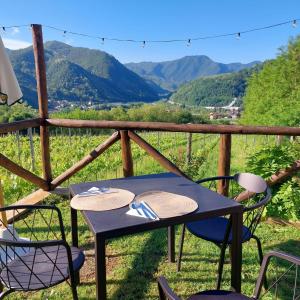 una mesa y sillas en un porche con vistas a las montañas en Agriturismo Tenuta La Fratta, en Bagni di Lucca