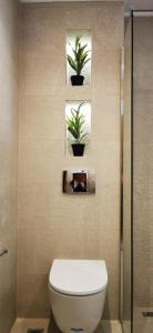a bathroom with a toilet and two potted plants at Casa Mameli Αpartments in Kallithea Halkidikis +104 photos