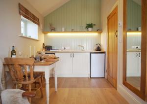 uma cozinha com uma mesa, um lavatório e um balcão em The Bothy em Carlton