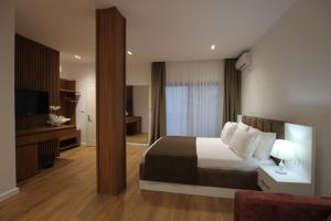 a hotel room with a bed and a television at ORCHIDS Hotel in Sarandë