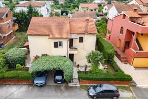 a house with two cars parked in a driveway at Apartments Mirella in Novigrad Istria