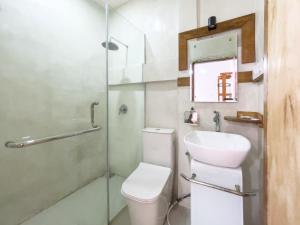 a bathroom with a toilet and a sink and a shower at Lara Homestay in Kuta Lombok