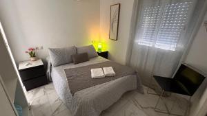 1 dormitorio con 1 cama con 2 toallas en Pensión Barlovento, en Málaga
