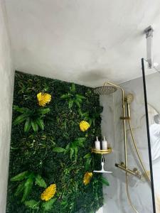a bathroom with a green wall with yellow flowers at l'evasion ,maison de ville jacuzzi couchages x6 in Le Grau-du-Roi