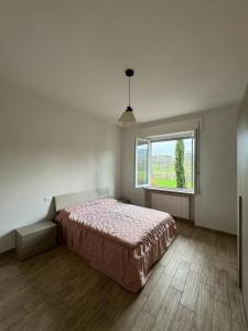 ein Schlafzimmer mit einem Bett und einem großen Fenster in der Unterkunft Villa Lilla 1 in Fivizzano