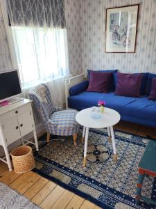 a living room with a blue couch and a table at Hotell Floras Trädgård in Öregrund