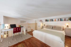 una camera da letto con un letto e una scrivania con una televisione di Bartolommeo Scala Loft by Mmega a Firenze