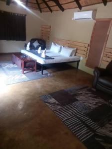 Camera con letto, tavolo e divano di Phokoje Bush Lodge a Selebi-Pikwe