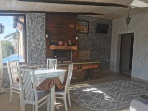 une salle à manger avec une table, des chaises et une cheminée dans l'établissement Monte-Kristo Hotel, à Kamianets-Podilsky