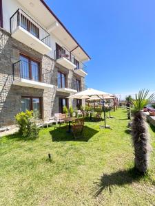 a building with a yard with tables and an umbrella at TERRA GAİA Hotel in Gokceada Town