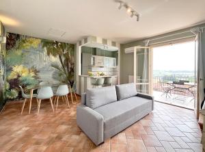 Una sala de estar con un sofá y una mesa con sillas. en Le Quiete Stanze, tra le colline e il mare, posto spiaggia e auto incluso, en Numana