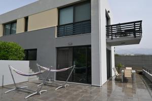 un edificio con 2 sillas en un patio en Μelpo's House en Kato Daratso