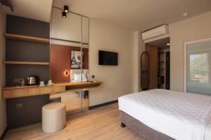 a bedroom with a bed and a desk and a television at Morina Deluxe Hotel in Oludeniz