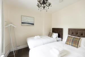 um quarto com 2 camas e um lustre em CHARLES STREET - Cottage at the edge of the Peak District National Park, Buxton em Buxton