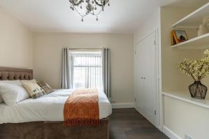 une chambre avec un grand lit et une fenêtre dans l'établissement Central Buxton - Modern Cottage - Peak District, à Buxton
