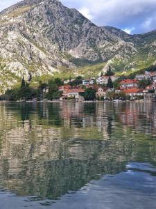 a reflection of a town in the water with a mountain at Sea side apartment in Kotor