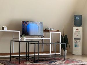 a living room with a tv and a table at Bintang Langit Lodge Ciater in Cicadas