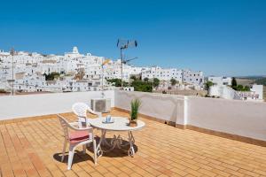 a patio with a table and chairs on a roof at Apartamento Callejon de La Fuente in Vejer de la Frontera +14 photos