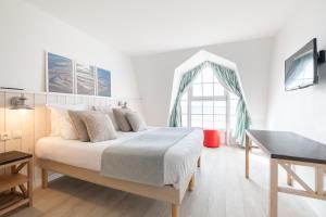Habitación blanca con cama grande y escritorio. en Pierre & Vacances Premium Résidence de la Plage en Le Crotoy