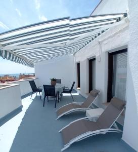 eine Terrasse mit Stühlen und einem Tisch auf dem Dach in der Unterkunft Apartament Les Cases in Les Cases d'Alcanar