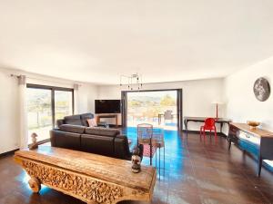 uma sala de estar com um sofá e uma mesa em Villa Livia Porticcio piscine 500m plage em Porticcio