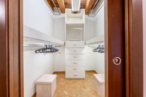 a walk in closet with white shelving at Sgarzerie Luxury Flat 2 rooms 120mq in Verona +43 photos