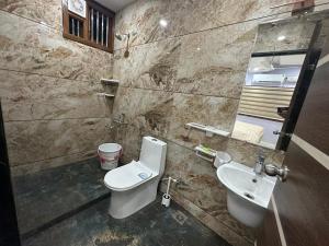 a bathroom with a toilet and a sink at TAJ ELEGANCE Luxury Service Apartment in Bhatkal +13 photos