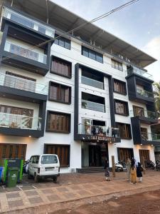 a white building with people standing outside of it at TAJ ELEGANCE Luxury Service Apartment in Bhatkal