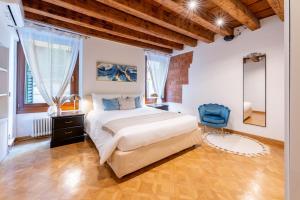 a bedroom with a large bed and a blue chair at Sgarzerie Luxury Flat 2 rooms 120mq in Verona