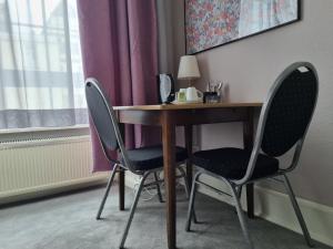 einen Schreibtisch mit 2 Stühlen und einen Tisch mit einer Lampe in der Unterkunft Only for Women on Tour in Bingen am Rhein