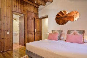 - une chambre avec un grand lit blanc et des oreillers roses dans l'établissement Luderna - Casa Coto Moreu, à Betrén