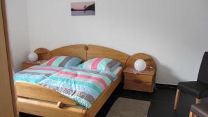 um quarto com uma cama de madeira e 2 almofadas em Ferienwohnung Am Alten Forsthaus Neuenbau em Neuenbau