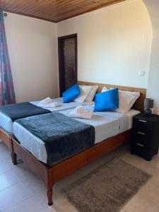 Duas camas num quarto com almofadas azuis em Suset Star II With Sea View na Calheta