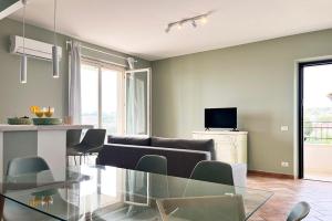 Una sala de estar con una mesa de cristal y un sofá. en Le Quiete Stanze, tra le colline e il mare, posto spiaggia e auto incluso, en Numana