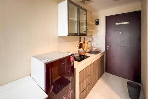 a small kitchen with a red and white refrigerator at RedLiving Springwood Residence - Living space in Warungmangga